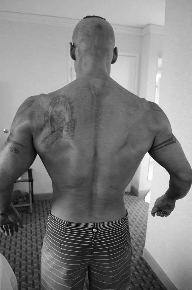 Black and white photo of a lifter from behind in a hotel room